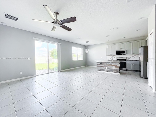 kitchen with a center island, light tile patterned floors, and stainless steel appliances