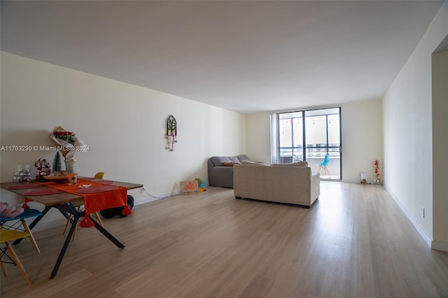 living room with light wood-type flooring and a wall of windows