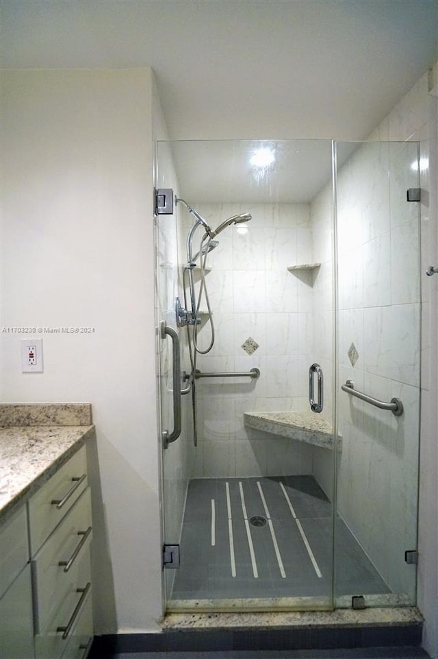 bathroom with vanity and a shower with shower door