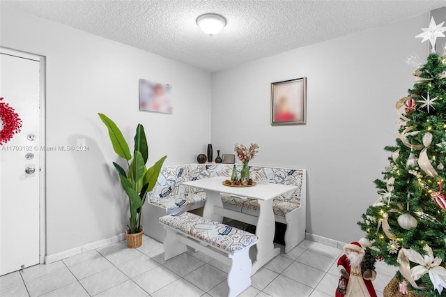 tiled dining room featuring a textured ceiling