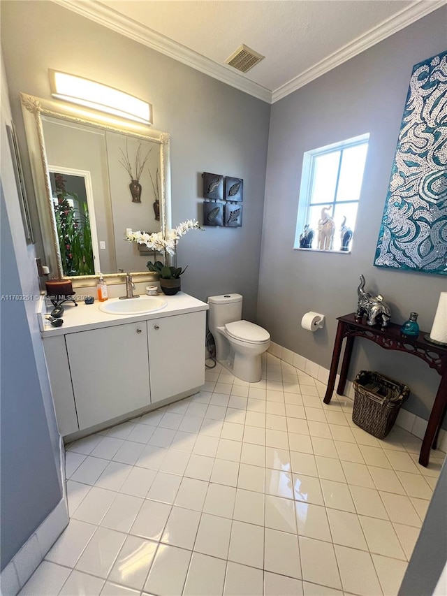 bathroom featuring visible vents, toilet, vanity, crown molding, and baseboards