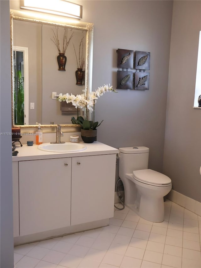 half bath featuring vanity, tile patterned flooring, and toilet