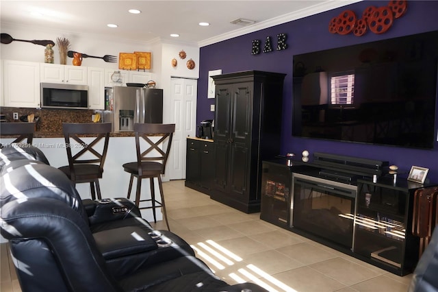 kitchen with crown molding, light tile patterned floors, stainless steel appliances, tasteful backsplash, and white cabinetry