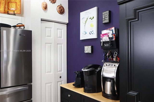 kitchen with light countertops, dark cabinetry, and freestanding refrigerator