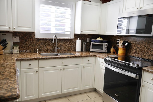 kitchen featuring white cabinetry, appliances with stainless steel finishes, tasteful backsplash, and a sink