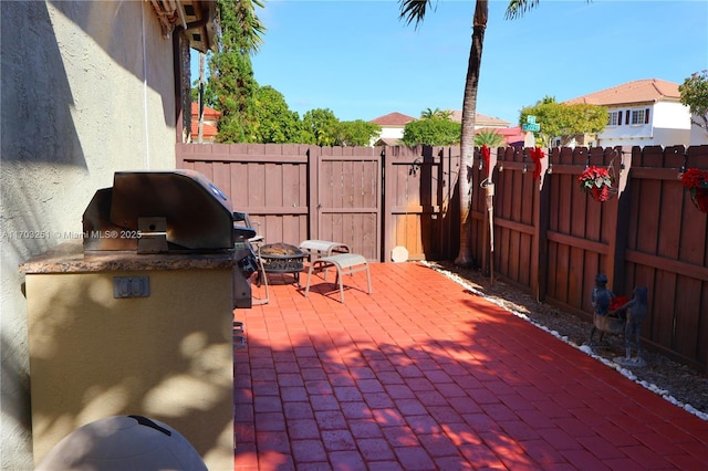 view of patio with a fenced backyard, an outdoor kitchen, and area for grilling