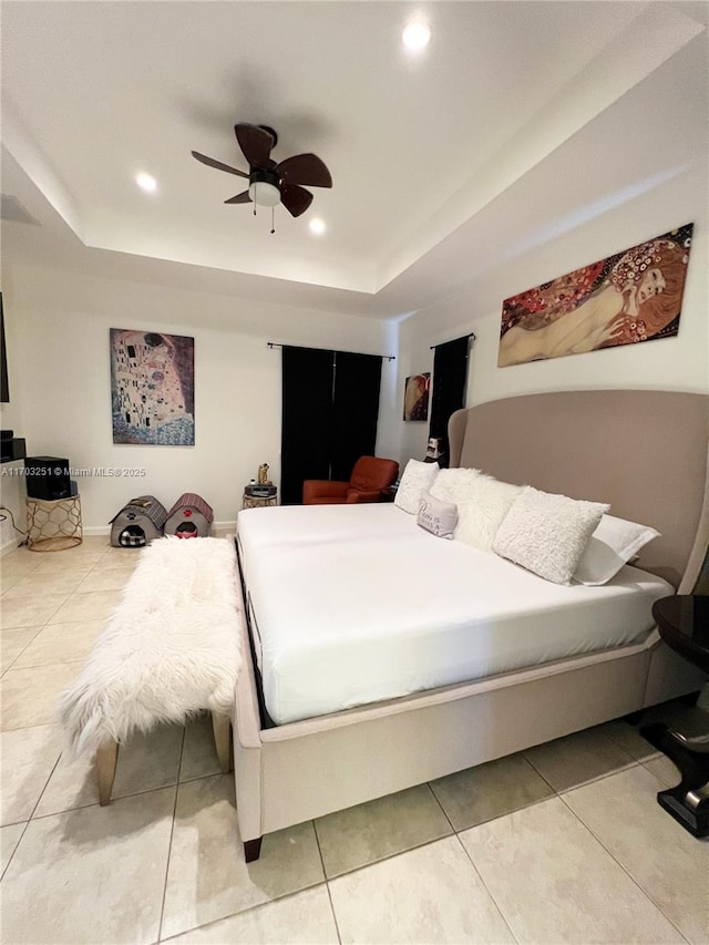 bedroom with a tray ceiling, tile patterned flooring, and recessed lighting