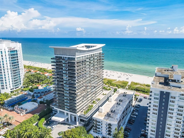 birds eye view of property with a water view and a beach view