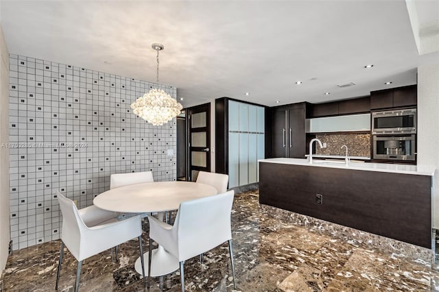 dining space with sink, tile walls, and a notable chandelier