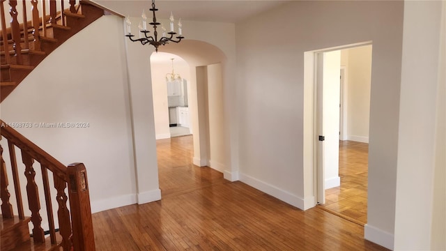 hallway with a chandelier and wood-type flooring