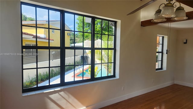 interior space with a wealth of natural light, hardwood / wood-style floors, and a notable chandelier