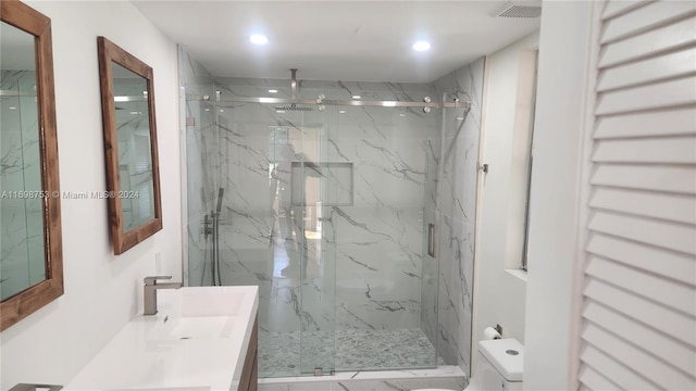 bathroom featuring vanity, toilet, and a shower with shower door