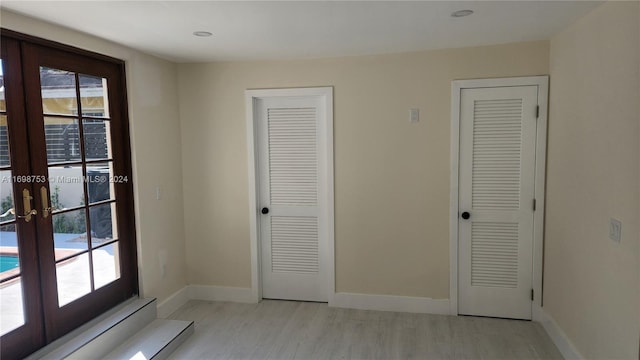 entryway with french doors and light hardwood / wood-style flooring