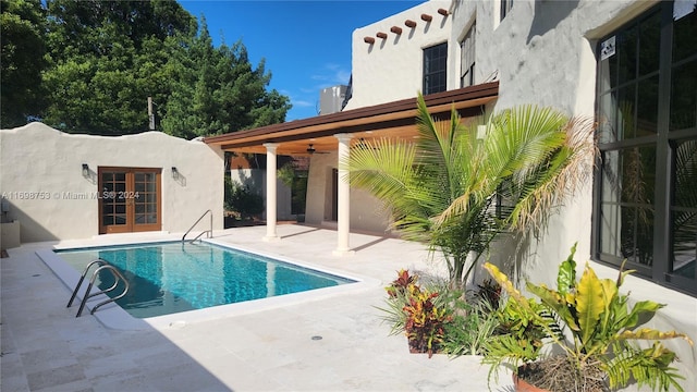 view of pool featuring french doors, ceiling fan, and a patio area