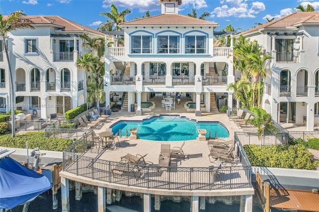 rear view of property with a community pool and a patio area