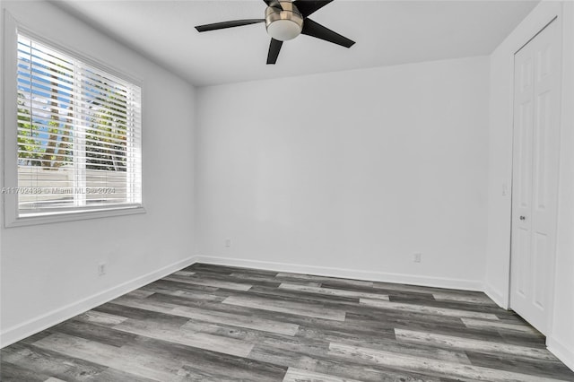 empty room with dark hardwood / wood-style flooring and ceiling fan