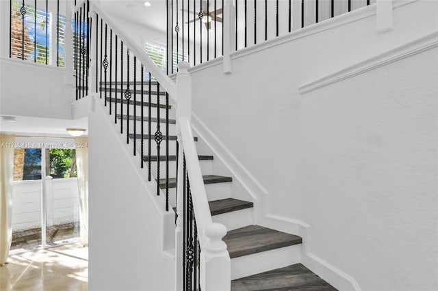 stairway with a wealth of natural light and hardwood / wood-style flooring