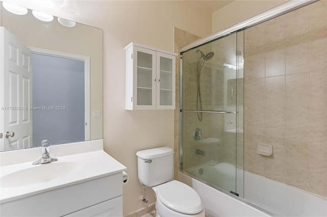 full bathroom featuring combined bath / shower with glass door, vanity, and toilet