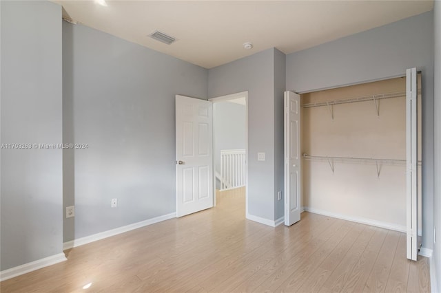 unfurnished bedroom with light wood-type flooring and a closet