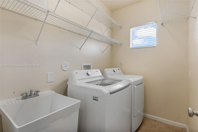 clothes washing area with independent washer and dryer, light tile patterned floors, and sink