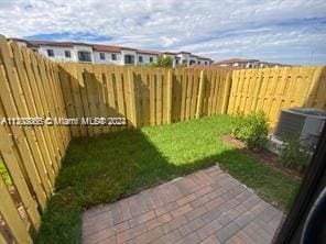 view of yard with central AC unit and a fenced backyard