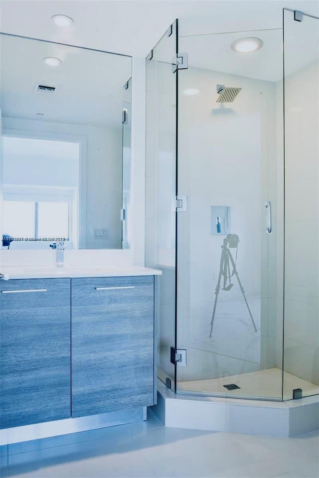 bathroom with vanity and a shower with shower door