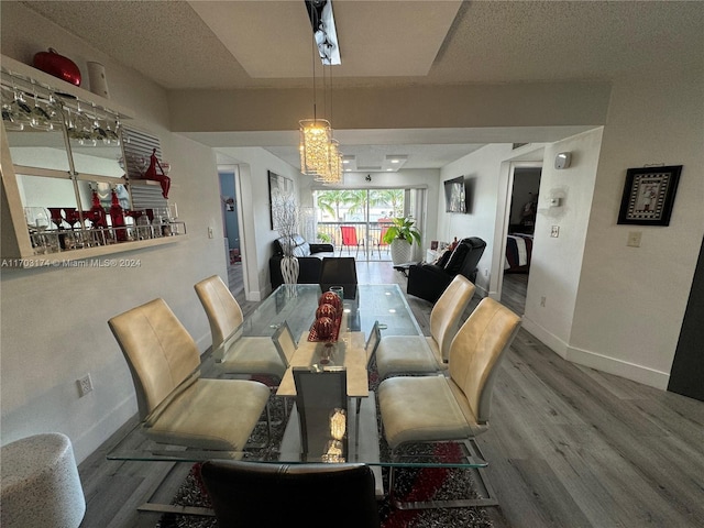 dining space with hardwood / wood-style flooring and a chandelier