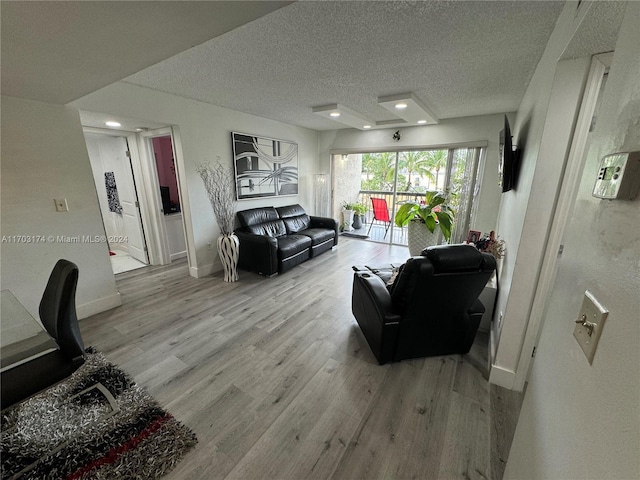 living room featuring a textured ceiling and light wood-type flooring