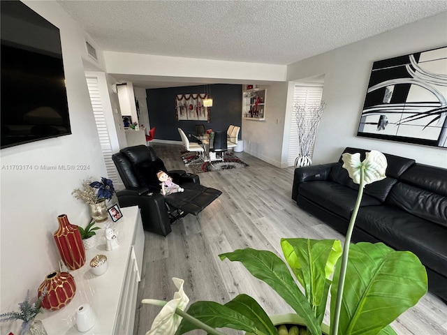 living room featuring a textured ceiling and light hardwood / wood-style floors