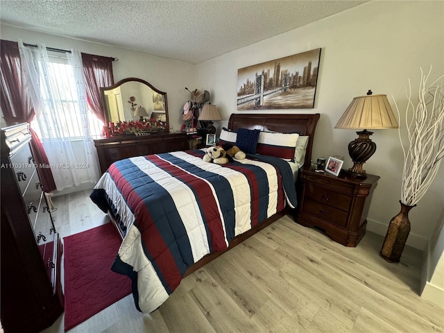 bedroom with light hardwood / wood-style floors and a textured ceiling