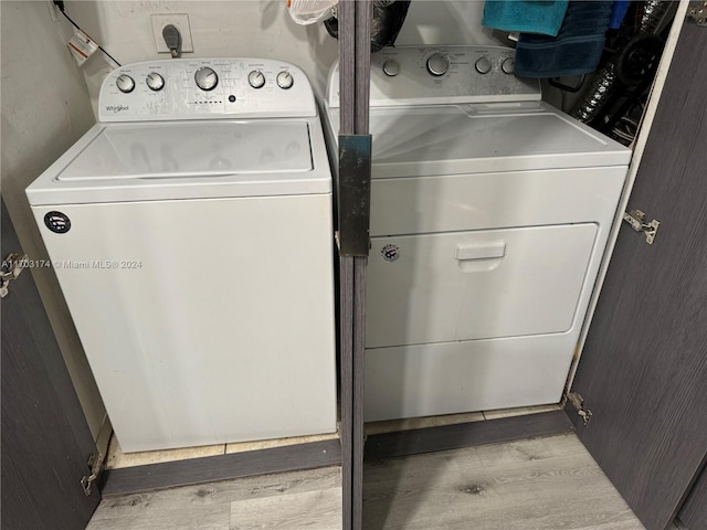 laundry area with light wood-type flooring and separate washer and dryer