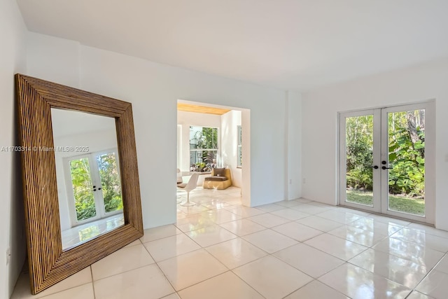 spare room featuring light tile patterned floors and french doors