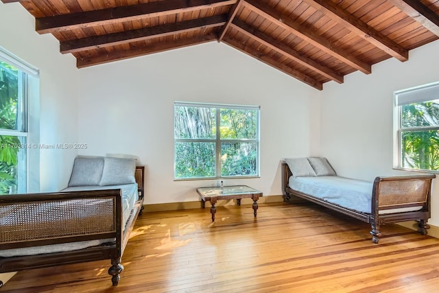 bedroom featuring beam ceiling, light hardwood / wood-style flooring, and wooden ceiling