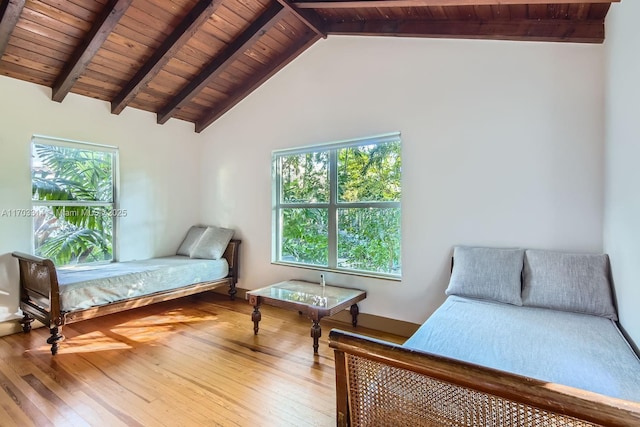 bedroom with vaulted ceiling with beams, hardwood / wood-style flooring, multiple windows, and wood ceiling