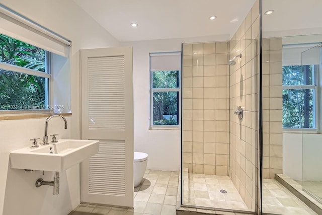 bathroom with tile patterned flooring, a tile shower, toilet, and sink