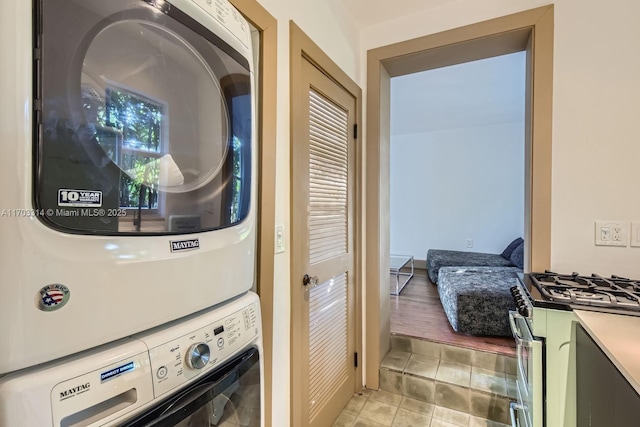 laundry room featuring light tile patterned flooring and stacked washing maching and dryer