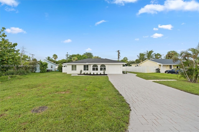 ranch-style home featuring a front lawn and a garage