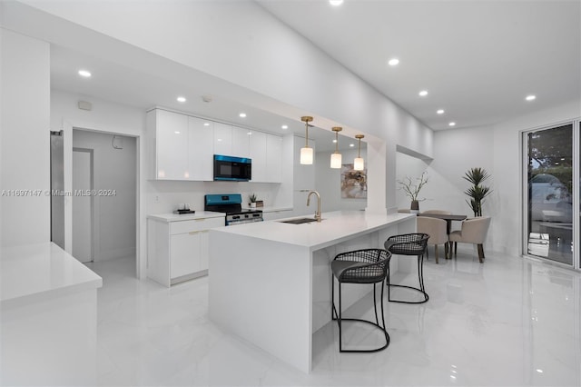 kitchen featuring sink, a kitchen breakfast bar, stainless steel range oven, decorative light fixtures, and white cabinets