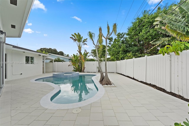 view of swimming pool featuring a patio area and an in ground hot tub