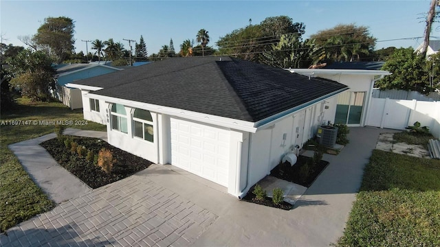 view of property exterior featuring a garage and central AC