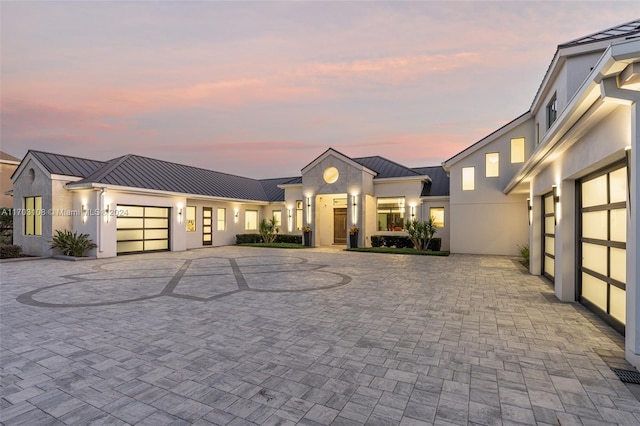 1410 Shadow Meadow Ln, Deland, FL 32724 - view of front of property featuring a standing seam roof, metal roof, a garage, curved driveway, and stucco siding