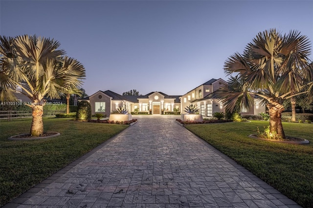 1410 Shadow Meadow Ln, Deland, FL 32724 - view of front of house featuring curved driveway, a front yard, and stucco siding