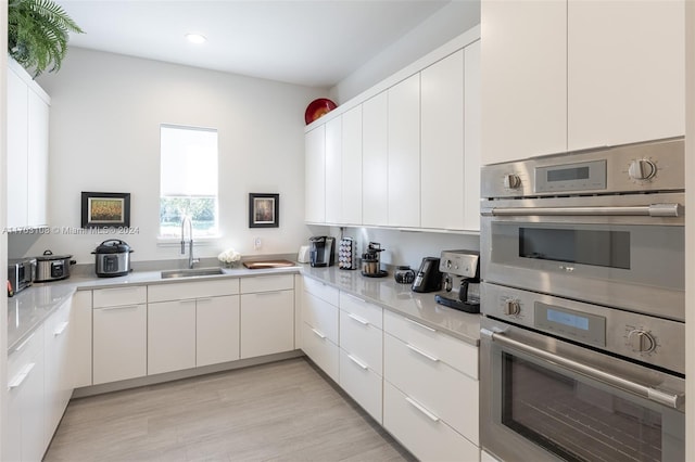1410 Shadow Meadow Ln, Deland, FL 32724 - kitchen featuring a sink, double oven, light countertops, white cabinets, and recessed lighting