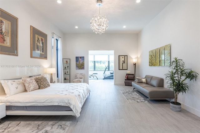 bedroom featuring access to outside, hardwood / wood-style floors, and a chandelier