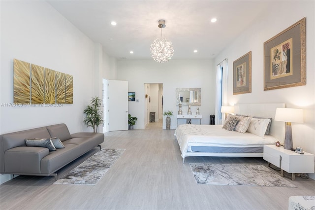 bedroom with light wood-type flooring and a notable chandelier