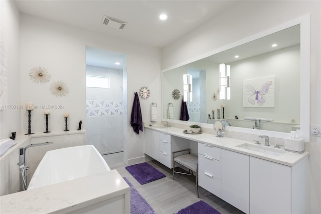 1410 Shadow Meadow Ln, Deland, FL 32724 - bathroom featuring double vanity, a freestanding tub, recessed lighting, a walk in shower, and wood finished floors