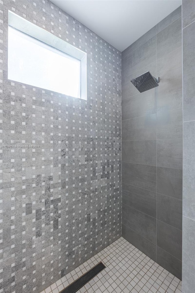 bathroom featuring tile patterned flooring and tiled shower