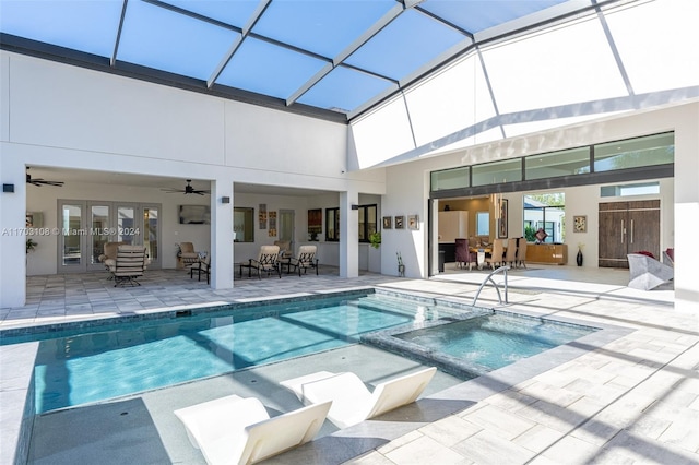 view of swimming pool featuring an in ground hot tub, a patio, glass enclosure, and ceiling fan