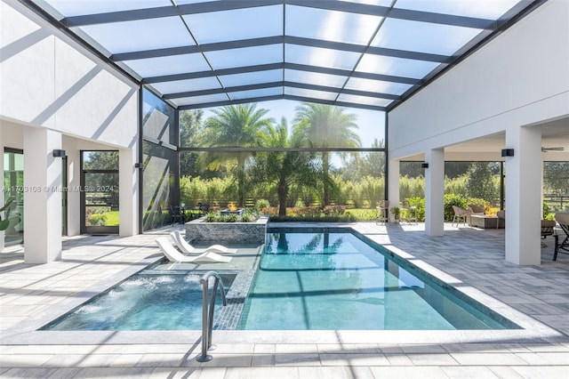 view of swimming pool with pool water feature, glass enclosure, a patio, and a hot tub