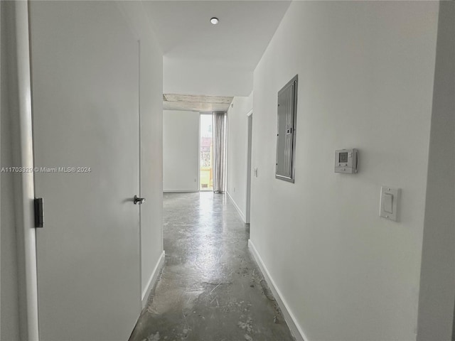 corridor featuring electric panel and concrete floors